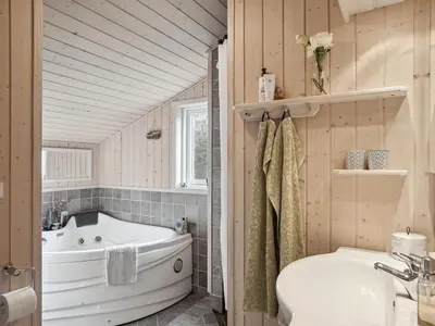 a bathroom with a tub and a sink at Holiday Home Sigbritt - 2-6km from the sea by Interhome in Blokhus