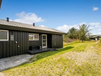 a home with a black house with a yard at Holiday Home Anbritt - 1km from the sea by Interhome in Saltum