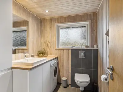 a bathroom with a sink and a washing machine at Holiday Home Anbritt - 1km from the sea by Interhome in Saltum