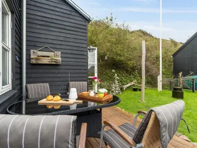 a patio with a table and chairs on a deck at Holiday Home Benni - 75m to the fjord by Interhome in Løgstør