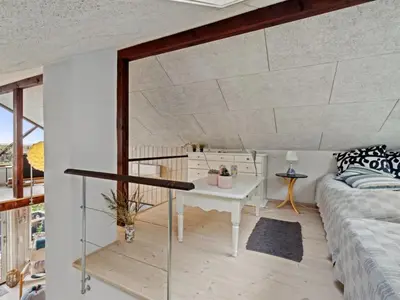 a living room with a bed and a table at Holiday Home Benni - 75m to the fjord by Interhome in Løgstør