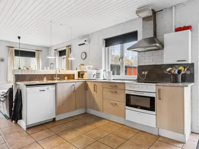 a kitchen with wooden cabinets and white appliances at Holiday Home Patrik - 200m to the fjord by Interhome in Fur