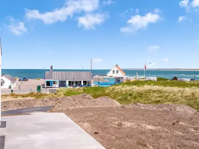 a building on the beach with the ocean in the background at Holiday Home Unge - 75m from the sea by Interhome in Torsted