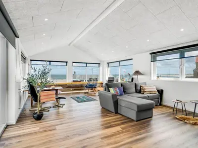 a living room with a couch and a table at Holiday Home Unge - 75m from the sea by Interhome in Torsted