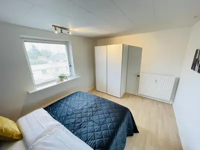 a bedroom with a bed and a window and a refrigerator at aday - Modern 3 bedrooms apartment in Svenstrup in Svenstrup