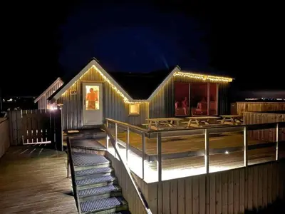 a house with a deck at night with lights at Boathouses dk - Besøg os direkte på hjemmesiden in Vinderup
