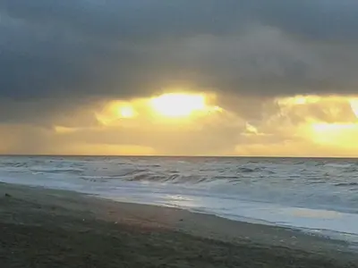 a sunset on the beach with a cloudy sky at 4 star holiday home in Blokhus-By Traum in Blokhus