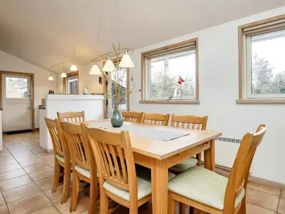 a kitchen and dining room with a wooden table and chairs at 4 star holiday home in Blokhus-By Traum in Blokhus