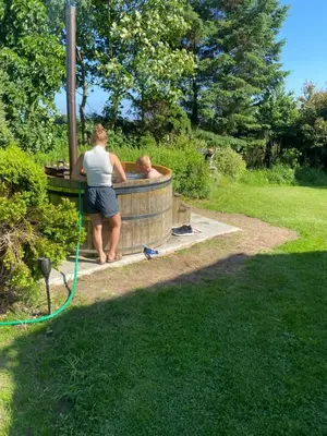a couple of people in a hot tub in a yard at Søbugten in Nykøbing Mors