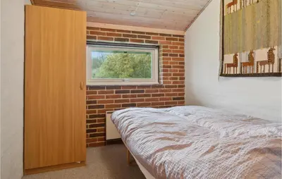 a bedroom with a bed and a brick wall at Lovely Home In Hurup Thy With Wifi in Sønder Ydby