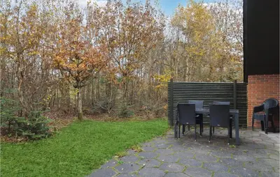 a patio with chairs and a table in a yard at Lovely Home In Hurup Thy With Wifi in Sønder Ydby