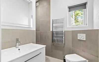 a bathroom with a sink and a toilet and a window at 3 Bedroom Cozy Home In Farsø in Farsø