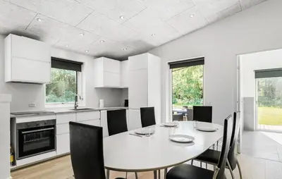 a kitchen and dining room with a table and chairs at 3 Bedroom Cozy Home In Farsø in Farsø