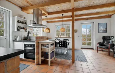 a kitchen with a stove and a dining room at 3 Bedroom Amazing Home In Fur in Fur