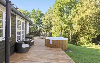 a wooden deck with a hot tub on the side of a house at 3 Bedroom Amazing Home In Fur in Fur
