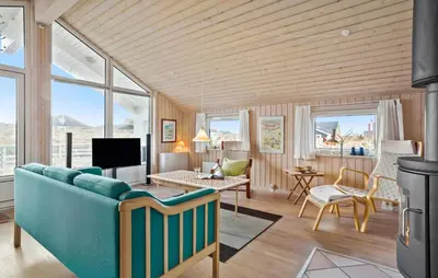a living room with a blue couch and a table at Amazing Home In Frøstrup With Sauna in Frøstrup