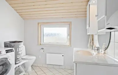 a white bathroom with a sink and a washing machine at Amazing Home In Frøstrup With Sauna in Frøstrup