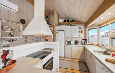 a kitchen with white appliances and a wooden ceiling at Beautiful Home In Vinderup With Sauna in Vinderup