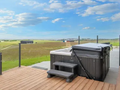 a barbecue grill on a deck with a view of a field at 5 star holiday home in Lemvig-By Traum in Lemvig