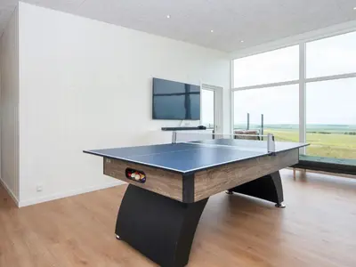 a ping pong table in a room with a tv at 5 star holiday home in Lemvig-By Traum in Lemvig