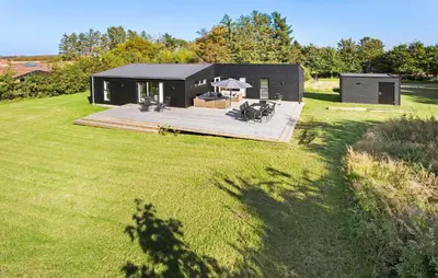 a black house on a field with a large yard at Amazing Home In Spøttrup With Wifi in Spottrup