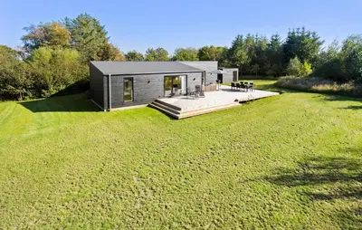 a small black cabin on a grass field at Amazing Home In Spøttrup With Wifi in Spottrup