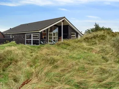 a house sitting on top of a grassy hill at Holiday Home Bruni - 400m from the sea by Interhome in Frøstrup