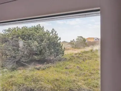 a window view of a field and a house at Holiday Home Bruni - 400m from the sea by Interhome in Frøstrup