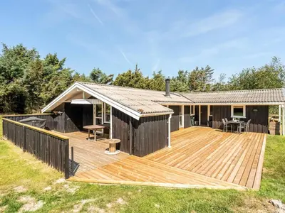 a wooden deck in front of a house at Holiday Home Thrineke - 600m from the sea by Interhome in Saltum