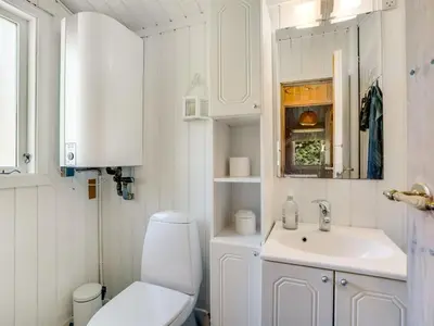 a white bathroom with a toilet and a sink at Holiday Home Thrineke - 600m from the sea by Interhome in Saltum
