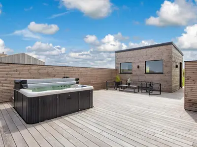a large deck with a hot tub on a patio at 5 star holiday home in Lemvig-By Traum in Lemvig