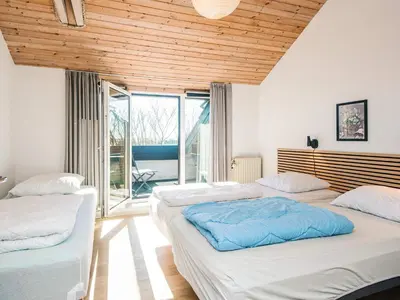two beds in a room with wooden ceilings at 20 person holiday home in Karby-By Traum in Karby