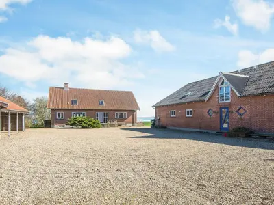 a house and a barn with a gravel driveway at 20 person holiday home in Karby-By Traum in Karby