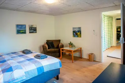 a bedroom with a bed and a chair and a table at Cosy One in Struer