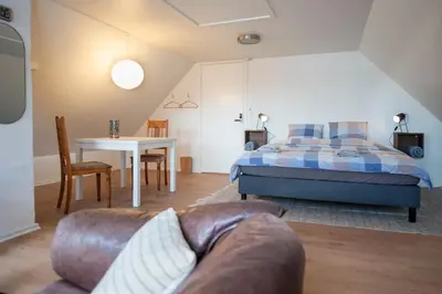 a bedroom with a bed and a table with a couch at Cosy One in Struer