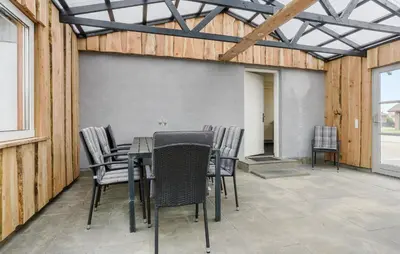 a table and chairs on a patio with a wall at Lovely Home In Vestervig With Wifi in Vestervig
