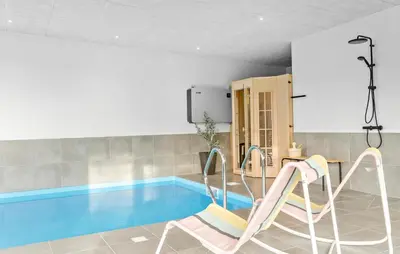 a room with a swimming pool with a slide at Amazing Home In Blokhus With Sauna in Blokhus