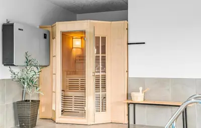 a wooden cabinet in a kitchen with a table at Amazing Home In Blokhus With Sauna in Blokhus