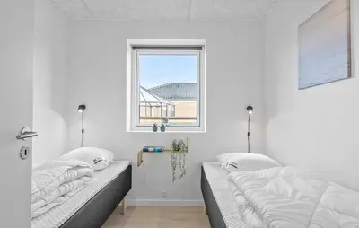 two beds in a white room with a window at Amazing Home In Blokhus With Sauna in Blokhus