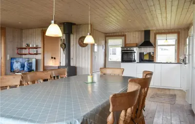 a kitchen and dining room with a table and chairs at Holiday Home Lemvig 12 in Lemvig