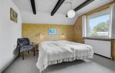 a bedroom with a large bed and a window at Holiday Home Thyholm 12 in Thyholm