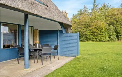 a patio with a table and chairs in a yard at Holiday Home Thyholm 12 in Thyholm