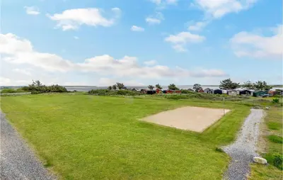 a grassy field with houses in the background at Pet Friendly Apartment In Vestervig in Vestervig