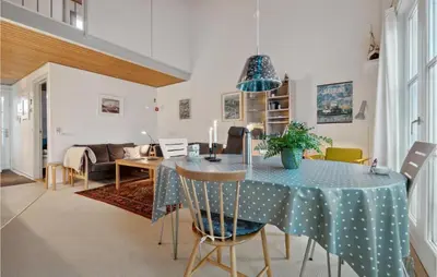 a dining room and living room with a table and chairs at Pet Friendly Apartment In Vestervig in Vestervig