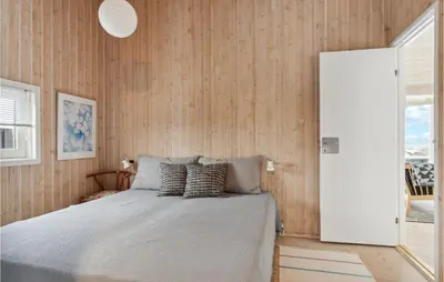a bedroom with a bed with wooden walls at Awesome Home In Saltum With Kitchen in Saltum