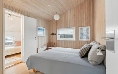 a bedroom with a bed and wooden walls at Awesome Home In Saltum With Kitchen in Saltum