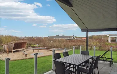 a patio with a table and chairs and a sandbox at Cozy Home In Vestervig With Sauna in Vestervig