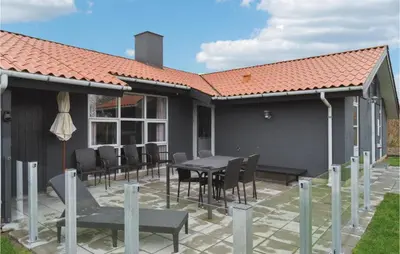 a house with a patio with a table and chairs at Cozy Home In Vestervig With Sauna in Vestervig