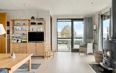 a living room with a television and a table at Amazing Home In Øster Assels With Wifi in Øster Assels