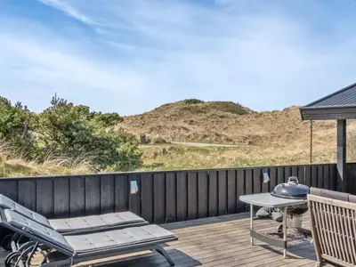 a patio with a table and chairs on a deck at Holiday Home Nikodina - 200m from the sea by Interhome in Saltum